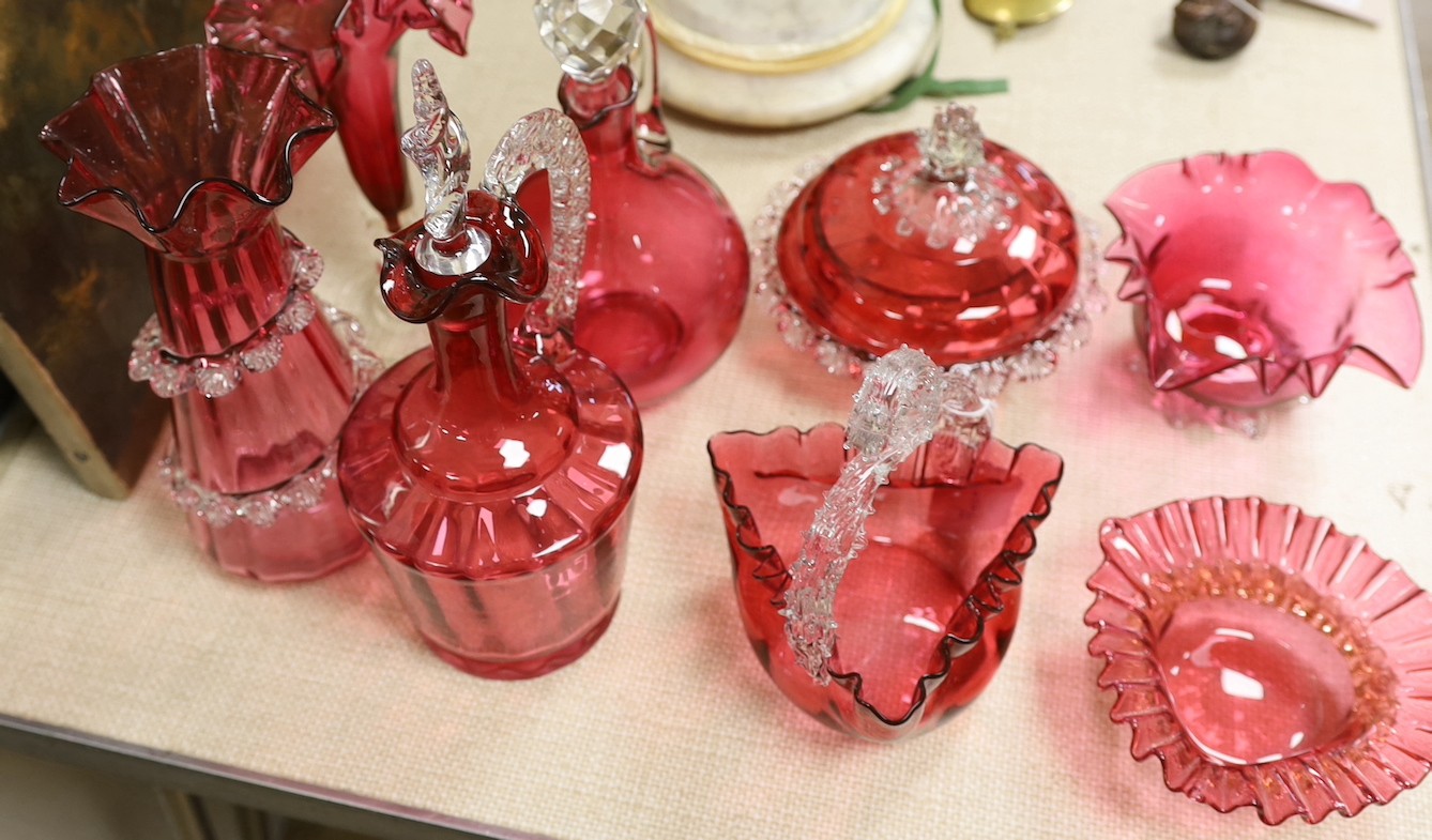 A Victorian cranberry glass decanters, a powder bowl, basket, two vases and two bowls., Tallest decanter 30 cms high.